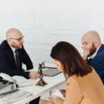 A serious legal consultation in a professional office environment involving three adults. - Photo by www.kaboompics.com on Pexels