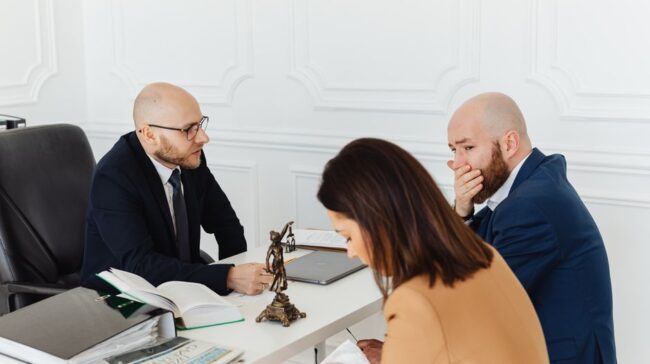 A serious legal consultation in a professional office environment involving three adults. - Photo by www.kaboompics.com on Pexels