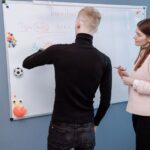 A student and teacher engage in an English lesson on a whiteboard. Indoor educational setting. - Photo by Thirdman on Pexels