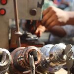 Close-up image of locksmith tools and hands working with a key machine outdoors. - Photo by Saad Bin Hasan on Pexels